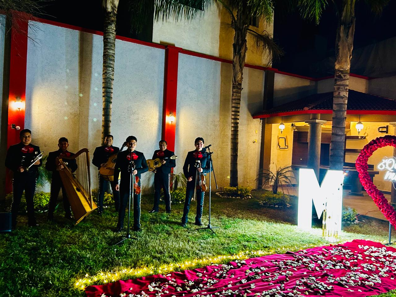 Mariachi en evento romántico con pétalos y luces